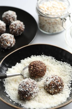 Beyaz masada fındıklı ve hindistan cevizli lezzetli çikolatalar yapmak, yakın plan.