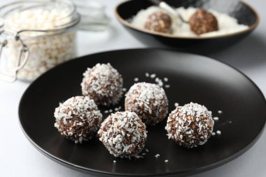 Beyaz masada hindistan cevizi taneli lezzetli çikolatalar, yakın plan.