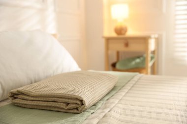 Evdeki çarşafların üzerine katlanmış havlu, yakın plan. Metin için boşluk
