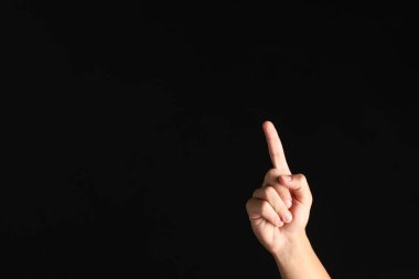 Siyah arka planda bir şeye dokunan adam, yakın plan. Metin için boşluk