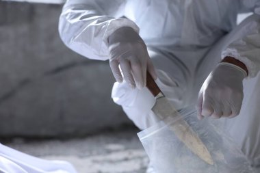 Olay yerinde kapalı mekanda çalışan adli tıp uzmanı, yakın çekim. Metin için boşluk