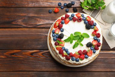 Tahta masanın üzerinde taze böğürtlenli leziz krep pastası. Metin için boşluk