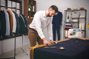 Moda tasarımcısı stüdyoda çalışıyor. Şık kıyafetler yaratmak