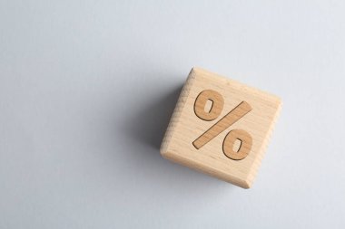 Açık gri arka planda yüzde işareti olan tahta küp, üst manzara. Metin için boşluk