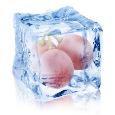 Beyaz zemin üzerinde buz küpünün içindeki taze üzümler