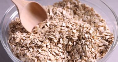 Masada kaşıkla yulaf ezmesi karıştıran kadın, yakın plan.