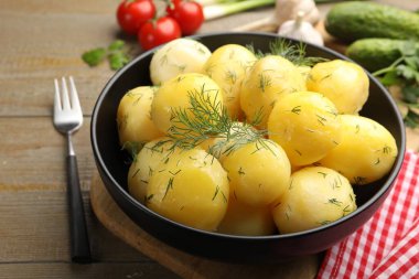 Ahşap masada, dereotlu ve yağlı leziz haşlanmış patatesler.