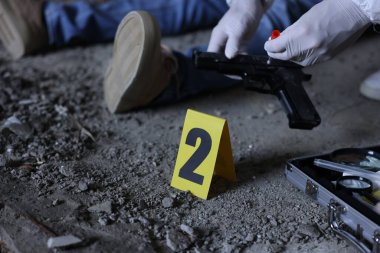 Adli tıp uzmanı olay yerinde çalışıyor. Terk edilmiş binanın içinde bir ceset var. Yakın plan.