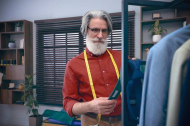 Moda tasarımcısı stüdyoda çalışıyor. Şık kıyafetler yaratmak