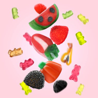 Tatlı jöle şekerler pembe arka plana düşüyor