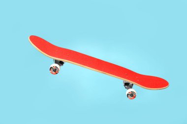 Açık mavi zemine karşı havada kırmızı kaykay