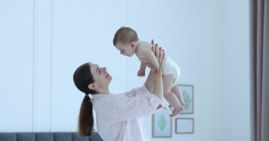 Anne evde küçük sevimli bebeğiyle eğleniyor.