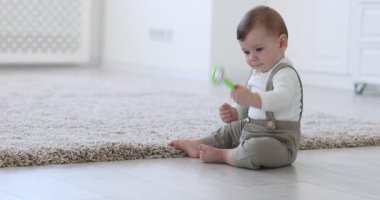 Evde oyuncakla oynayan sevimli küçük bebek, kamera içeri giriyor.