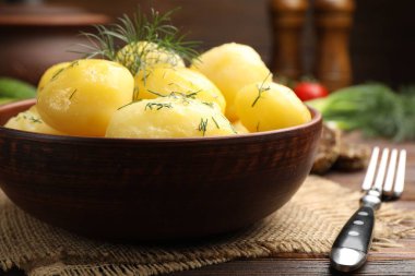 Ahşap masada, dereotlu ve yağlı leziz haşlanmış patatesler.