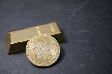 Kripto para birimi. Siyah masanın üzerinde bir altın ve altın külçe, yakın plan. Metin için boşluk