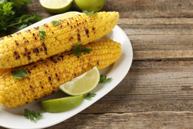 Maydanozlu mısır koçanları ve ahşap masada limon dilimleri, yakın plan. Metin için boşluk