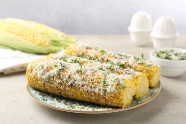 Maydanozlu ve peynirli mısır koçanları ışık masasında, yakın plan.