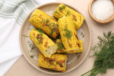 Lezzetli ızgara mısır koçanları ahşap masa üzerinde dereotu, düz yatıyordu.