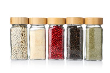 Beyaz kavanozlardaki farklı aromatik baharatlar.