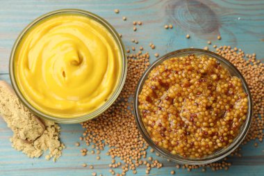 Açık mavi ahşap masa üzerinde farklı hardal türleri, düz yatıyordu.