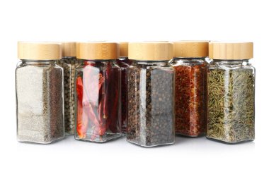 Beyaz kavanozlardaki farklı aromatik baharatlar.