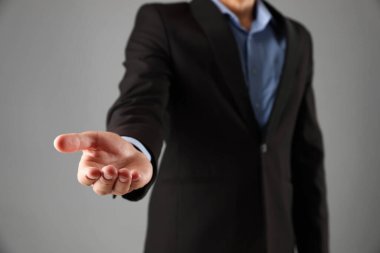 Gri arkaplanda bir şey tutan adam, yakın plan.