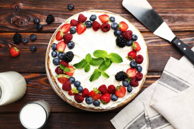 Tahta masada servis edilen taze böğürtlenli leziz krep keki.