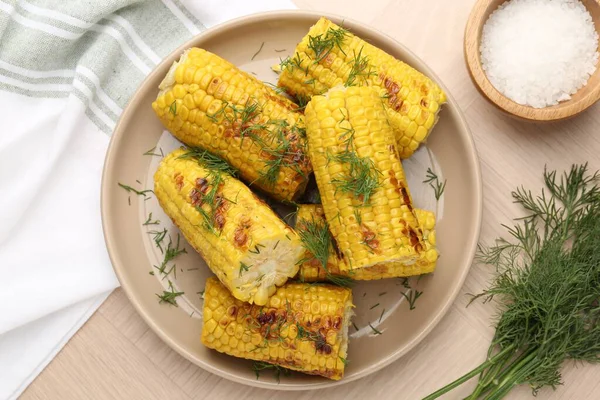 Lezzetli ızgara mısır koçanları ahşap masa üzerinde dereotu, düz yatıyordu.