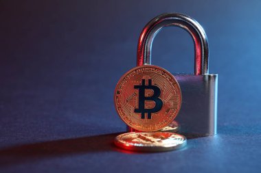 Mavi arkaplanda kırmızı ışıkta bitcoinler ve asma kilit, metin için boşluk ile yakın çekim