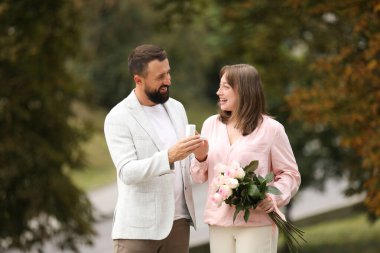 Nişan yüzüklü bir adam kız arkadaşına dışarıda evlenme teklif ediyor.