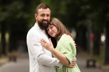 Evlilik teklifi yapıyor. Nişan yüzüğü gösteren ve dışarıda nişanlısına sarılan bir kadın.