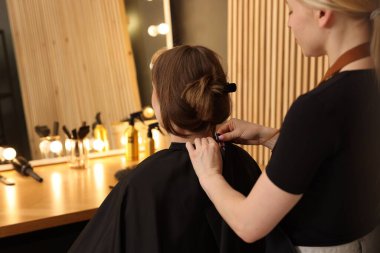 Kuaför müşteriyle kuaförde çalışıyor, yakın plan.