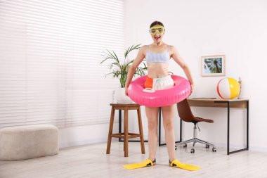 Dalgıç maskeli mutlu kadın ve şişme yüzüklü paletler evde eğleniyor, mesaj için yer var. Denizde tatilin hayalini kuruyorum.