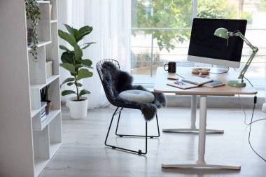 Ev çalışma alanı. Modern bilgisayar, ev bitkisi ve kırtasiye malzemesi ahşap masa içinde.