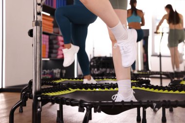 Spor salonundaki tramplenlerde antrenman yapan kadınlar, yakın çekim.