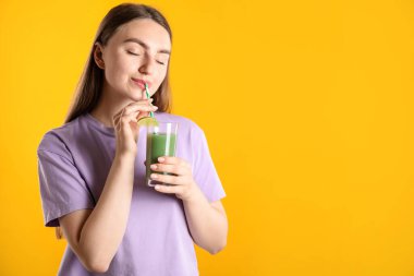 Turuncu arka planda samandan ferahlatıcı içecek içen kadın, mesaj için yer