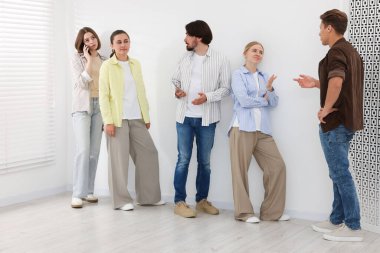 Bir grup insan içeride kuyrukta bekliyor.