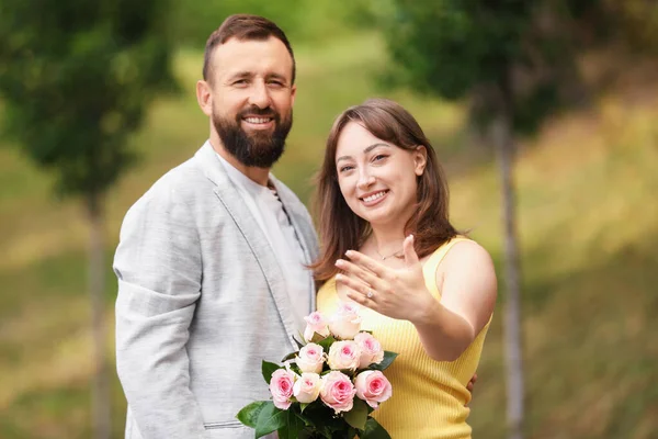 Evlilik teklifi yapıyor. Nişan yüzüğü ve nişanlısı dışarıda.