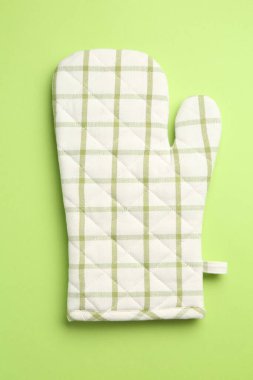 Yeşil arka planda bir fırın eldiveni, üst manzara.