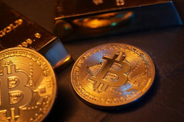 Kripto para birimi. Altın bitcoin ve altın külçeler siyah masanın üzerinde, yakın plan