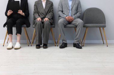 İnsanlar içeride sandalyelerde kuyrukta bekliyor, yakın çekim.