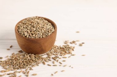 Çavdar taneleri kasede, beyaz ahşap masada, yakın plan. Metin için boşluk