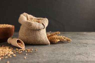 Gri masada buğday taneleri ve çiviler, yakın plan. Metin için boşluk