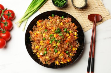 Lezzetli pilav ve yemek çubukları beyaz mermer masada, düz yerde.