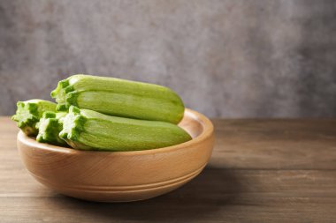 Tahta masadaki kasede taze olgun kabaklar, yakın plan. Metin için boşluk