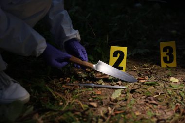 Adli tıp uzmanı dışarıdaki suç mahallinde çalışıyor, yakın plan.