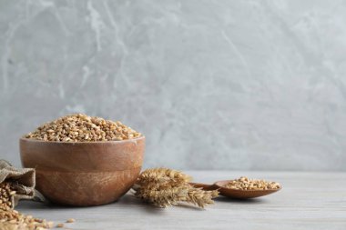 Buğday taneleri ve çiviler açık ahşap masada. Metin için boşluk