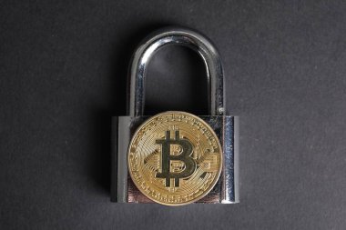 Gri arkaplanda bitcoin ve asma kilit, üst görünüm