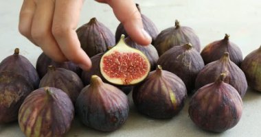 Gri masada incir kıran kadın, yakın plan.