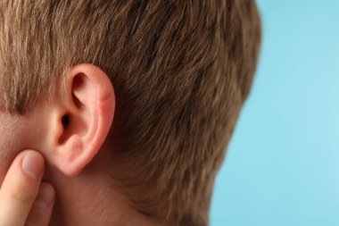 Ses geliyor. Açık mavi arka plandaki adam, yakın plan. Metin için boşluk